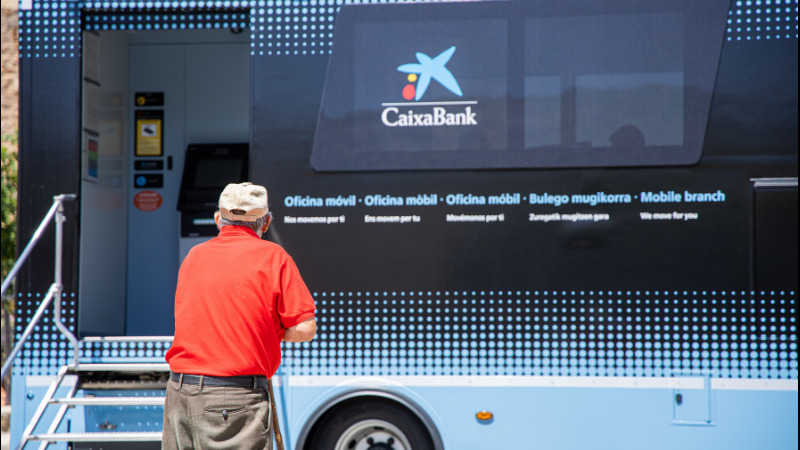 Imatge de l&rsquo;oficina m&ograve;bil de CaixaBank amb un home gran en primer pla