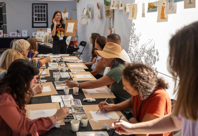 Durant el taller, un grup de persones participa activament en activitats creatives, educatives i socials.