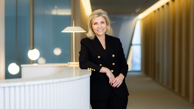 Bel&eacute;n Mart&iacute;n, amb un vestit negre elegant, recolzada en un taulell blanc dins d&rsquo;un espai modern i ben il&middot;luminat.