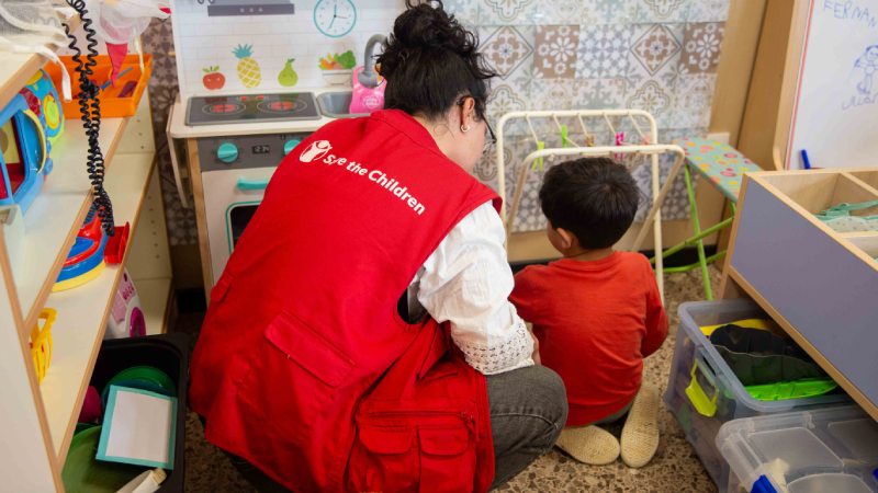 Treballadora de Save the Children amb un nen Una treballadora de Save the Children juga amb un nen