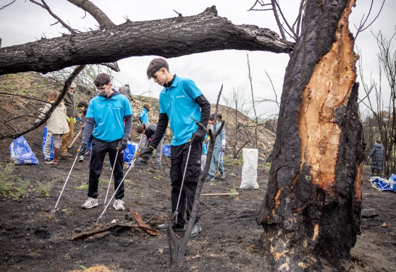 Joves voluntaris de CaixaBank treballen netejant un espai natural