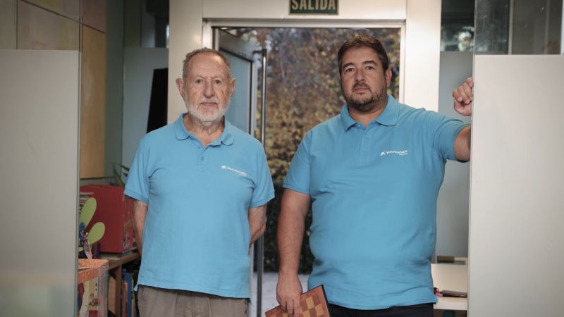Alberto i el seu pare, voluntaris amb nens als quals ensenyen escacs