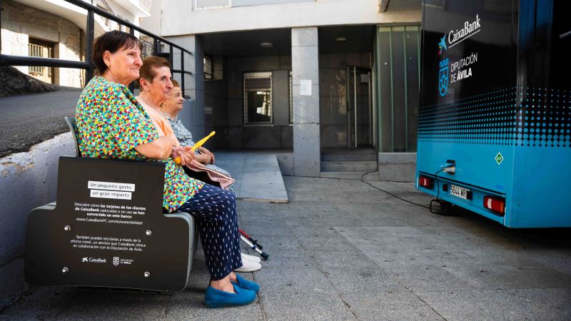 Bancs fabricats amb targetes reciclades a l’Espanya rural Veïnes de Serranillos (Àvila) assegudes en un banc elaborat amb targetes reciclades, al costat d’una oficina mòbil de CaixaBank.