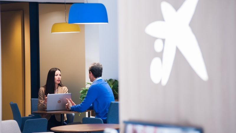 El valor és permetre que els clients triïn el canal que millor s’adapti a les seves necessitats. Un gestor de CaixaBank atén un client en una de les oficines del banc.