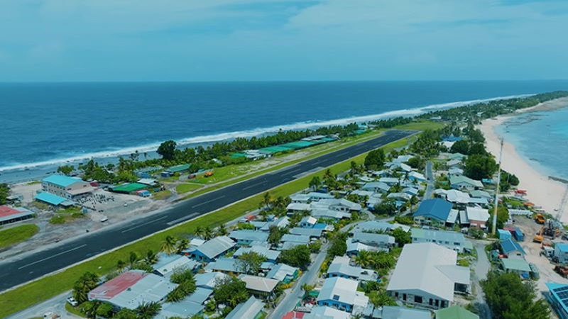 Tuvalu és un dels països més petits i aïllats del planeta Vista aèria de Tuvalu, amb pista d’aterratge, habitatges i platges envoltades per l’oceà, que representa una comunitat costanera en un entorn tropical