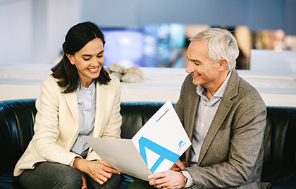 Hombre y mujer conversando con una carpeta de CaixaBank accionistas