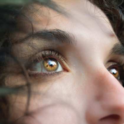 Primer plano de los ojos color marrón con tonalidades amarillas de una mujer.