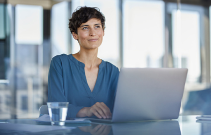 Mujer con un portátil trabajando en las oficinas de CaixaBank