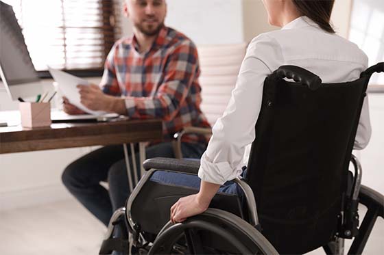 Mujer en silla de ruedas haciendo una entrevista de trabajo en un centro especial de ocupación de CaixaBank