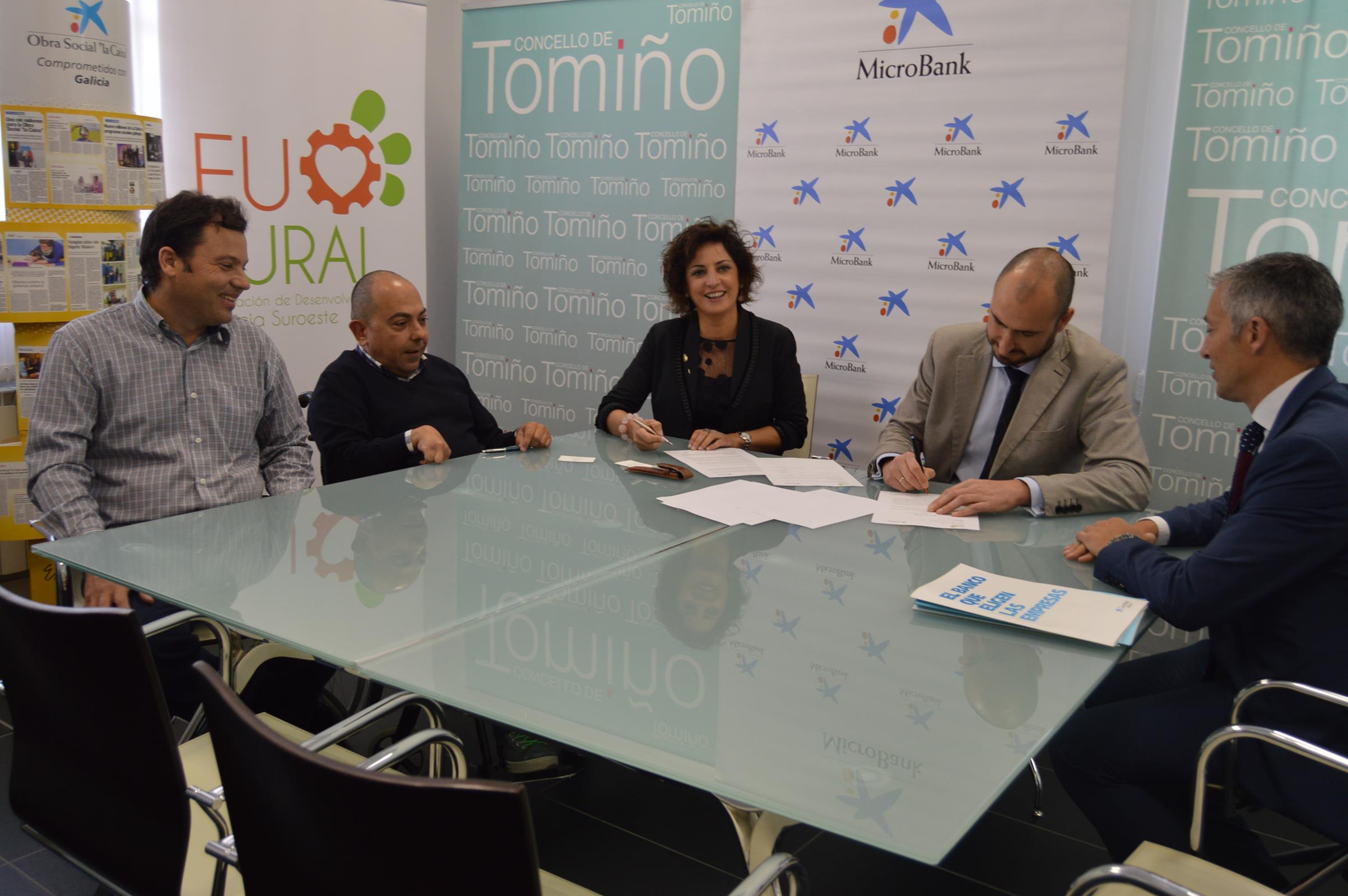 Sandra González, presidenta de la Asociación Desenvolvemento Rural MAIV – Baixo Miño, e Igor de las Heras, director del Área de Negocio de CaixaBank en Pontevedra Sur (en el centro de la foto), durante la firma del convenio