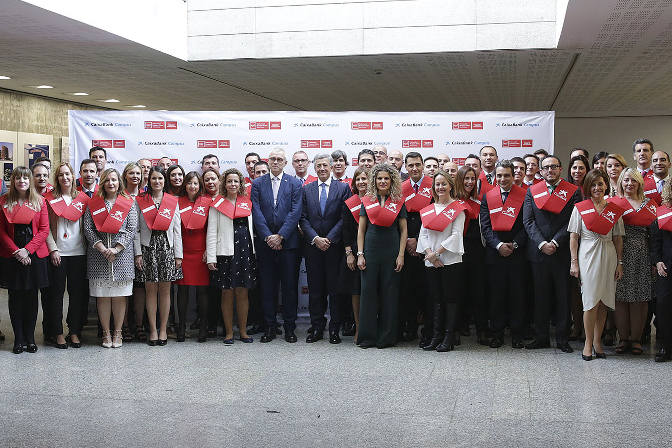 El director de RR.HH. y Organización de CaixaBank, Xavier Coll, y el rector de la UPF, Jaume Casals, con los empleados graduados.