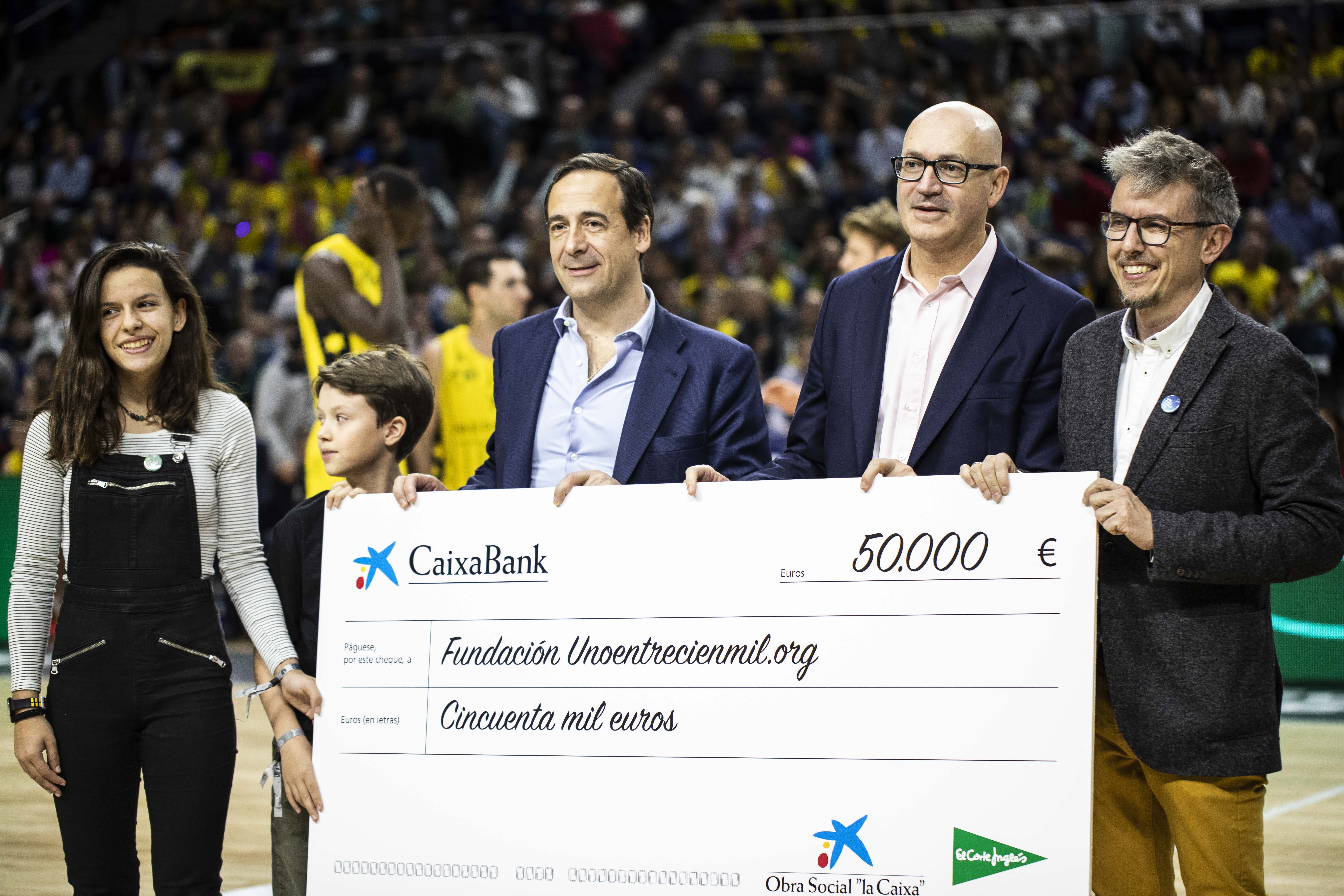 Gonzalo Gortázar, consejero delegado de CaixaBank, entrega el cheque a la Fundación Unoentrecienmil