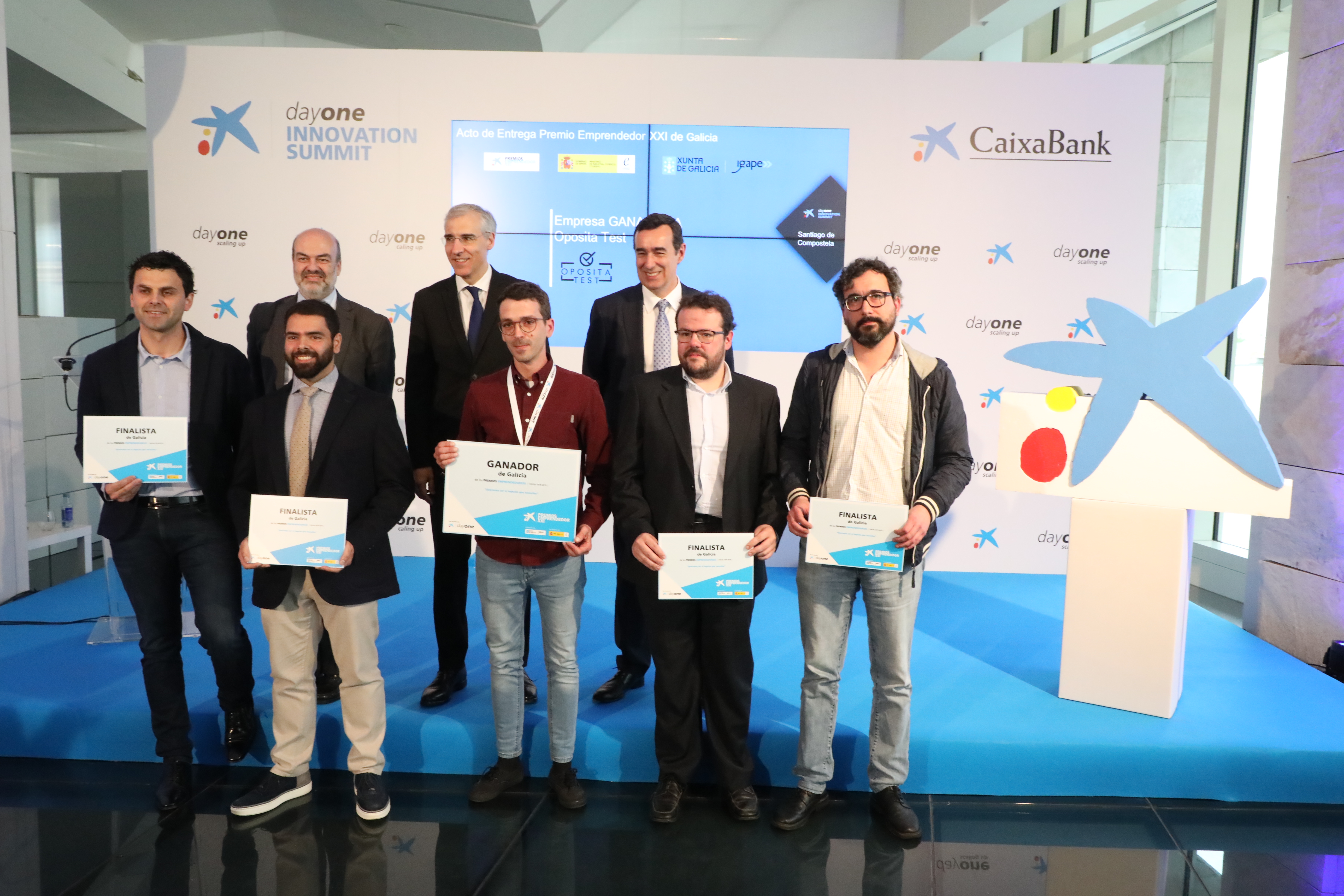 Representante de la empresa ganadora, acompañado por miembros de las otras cuatro empresas finalistas y representantes institucionales
