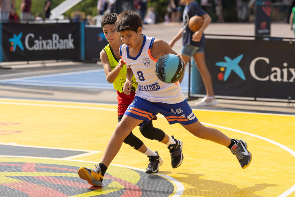 Dos nens participen en la parada del Plaza 3x3 CaixaBank a Barcelona, circuit de basquetbol patrocinat per CaixaBank