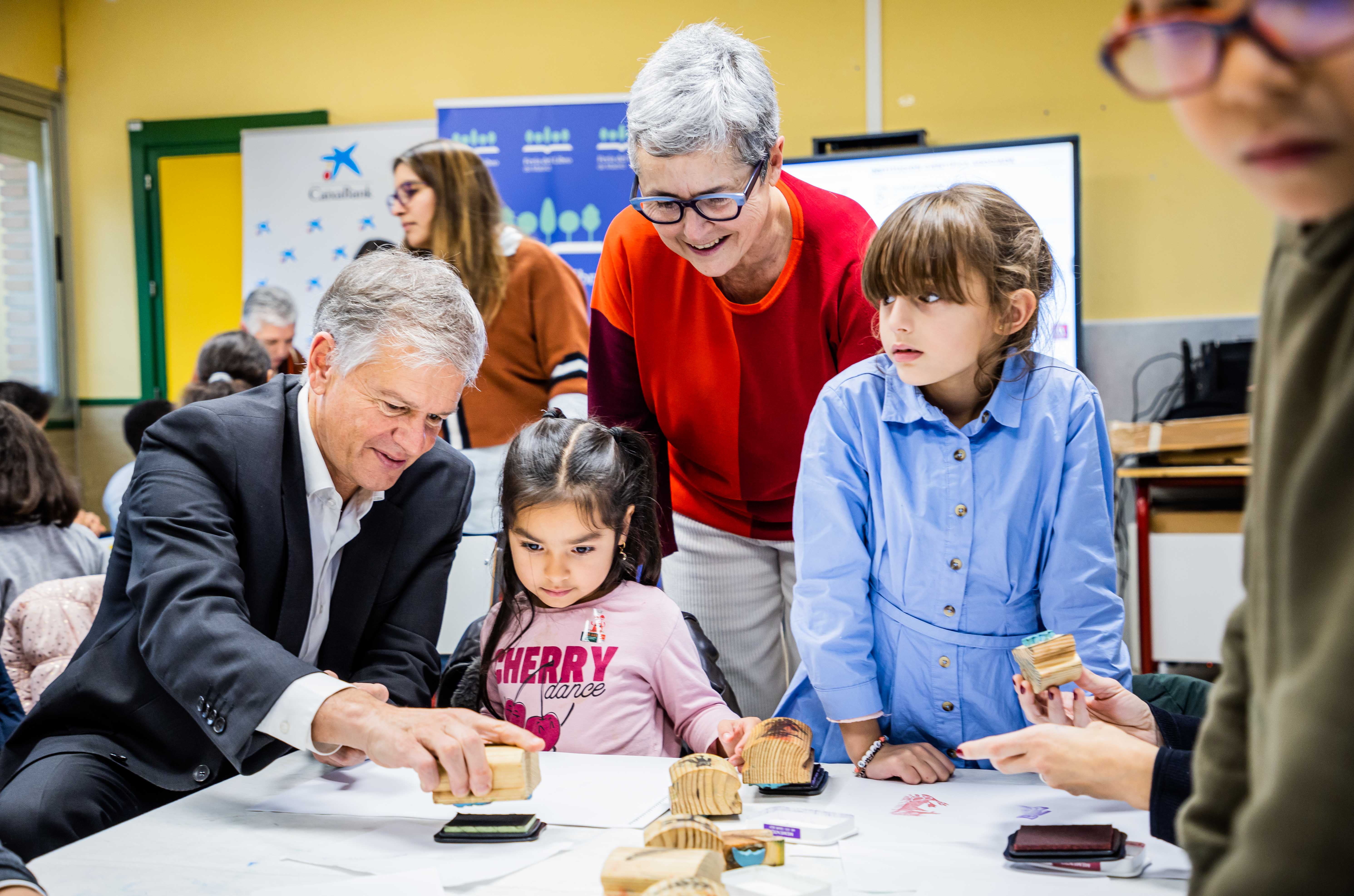 Menores de la Asociación Valdeperales que han participado en ‘El vaivén de la Feria’ junto al director territorial de CaixaBank en Madrid, Xicu Costa; y la directora de la Feria del Libro, Eva Orúe.