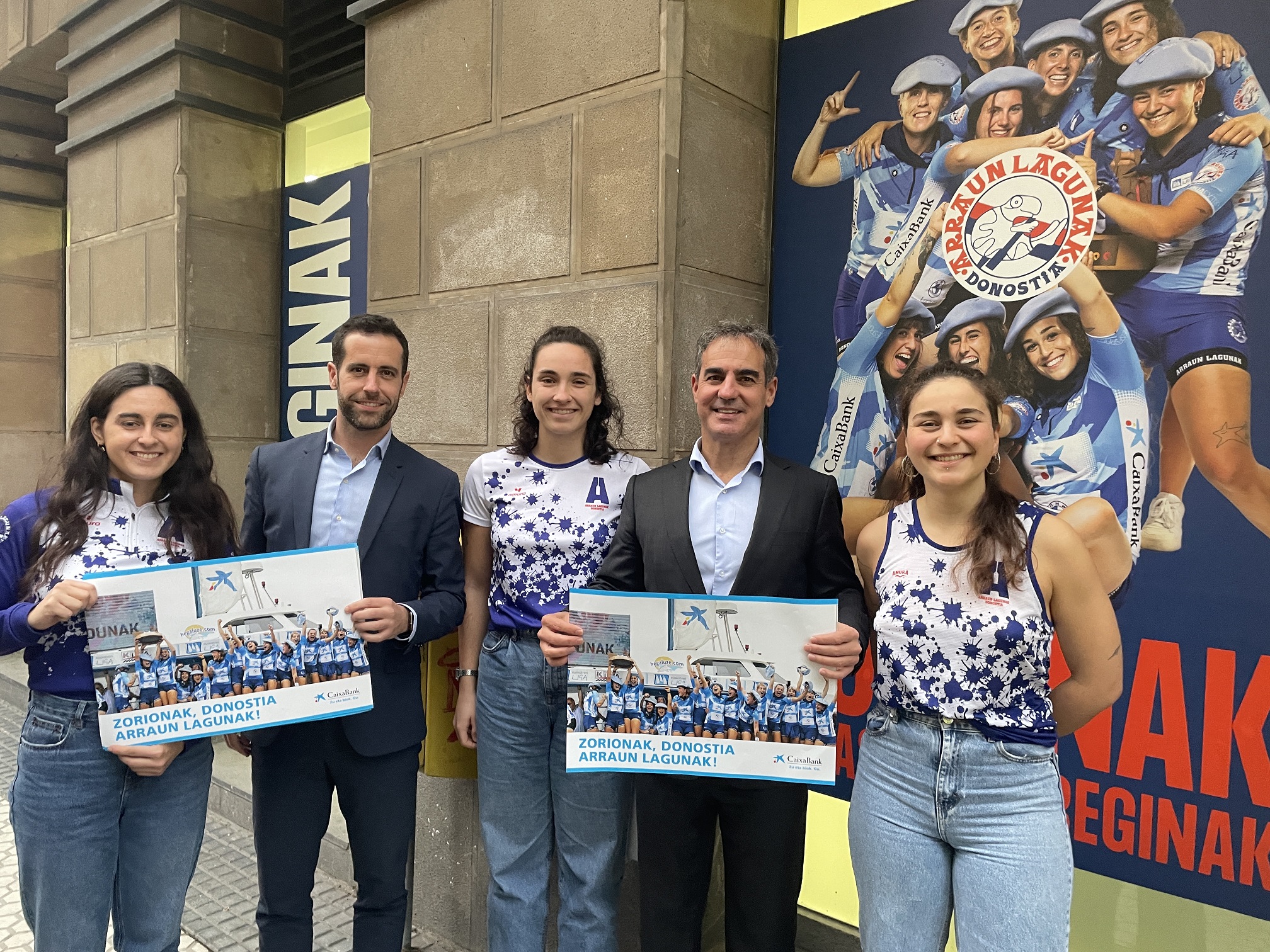 Nicolas Sotres, director de la oficina de CaixaBank, y Ángel Garabieta, Director Comercial de CaixaBank, junto a las remeras de Arraun Lagunak