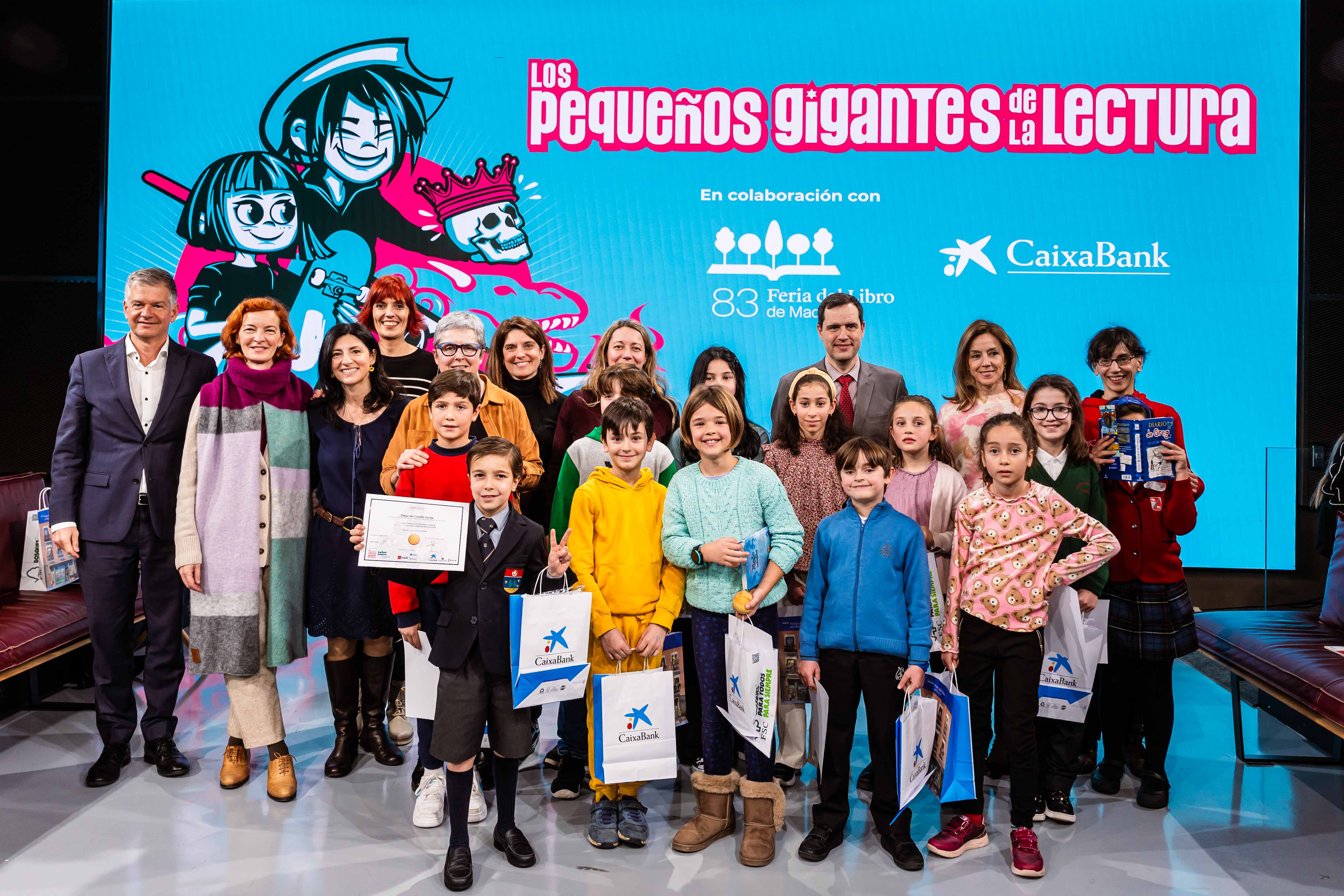 El director territorial de CaixaBank en Madrid, Xicu Costa; la directora de la Feria del Libro de Madrid, Eva Orúe; y la impulsora del juego ‘Los pequeños gigantes de la lectura’, Magali Guerrero, en la final autonómica de Madrid junto a los ganadores y a los finalistas.