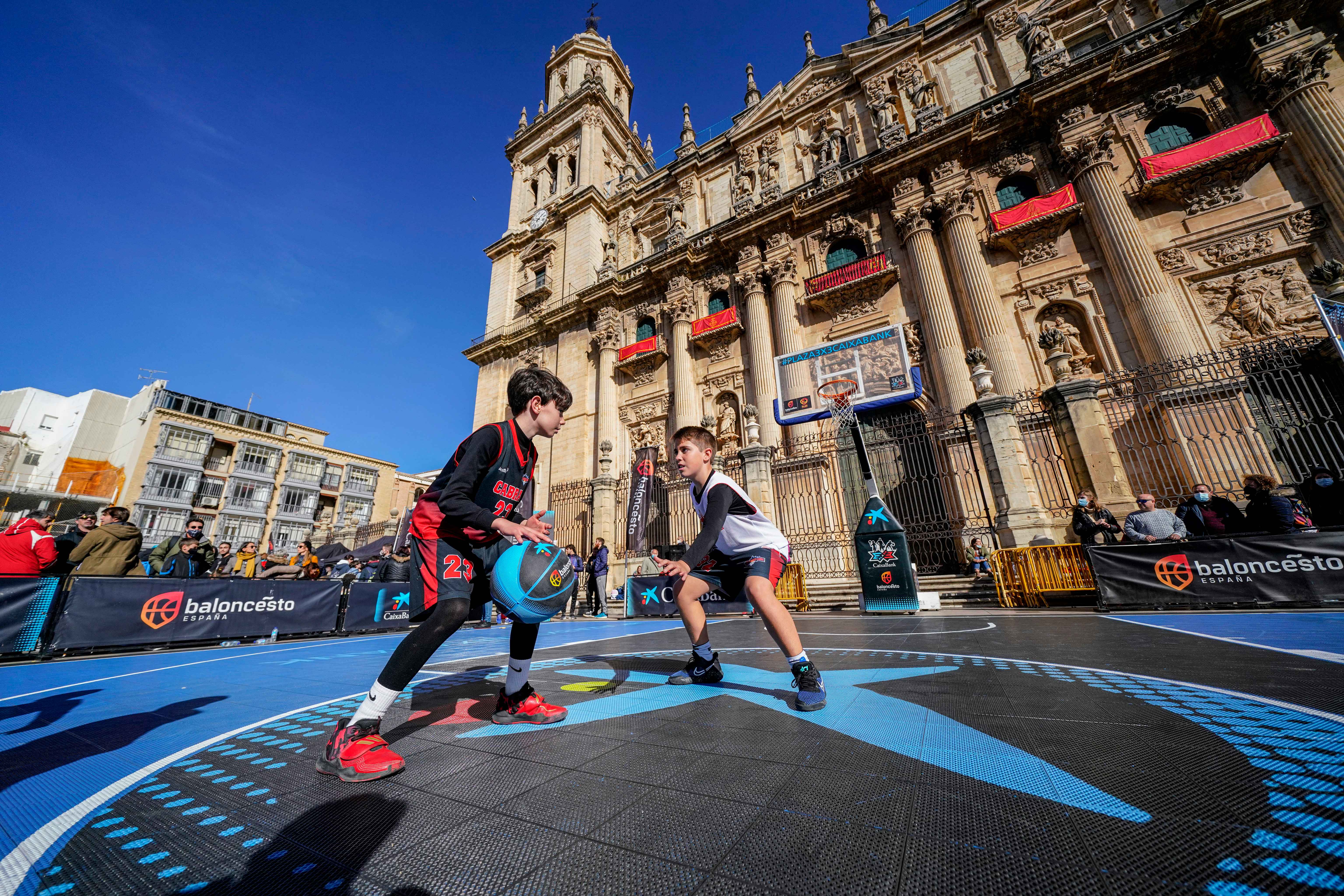 Dos niños participan en una de las paradas del Plaza 3x3 CaixaBank, uno de los proyectos de baloncesto formativo que impulsan la FEB y CaixaBank en el marco del patrocinio de la entidad financiera.