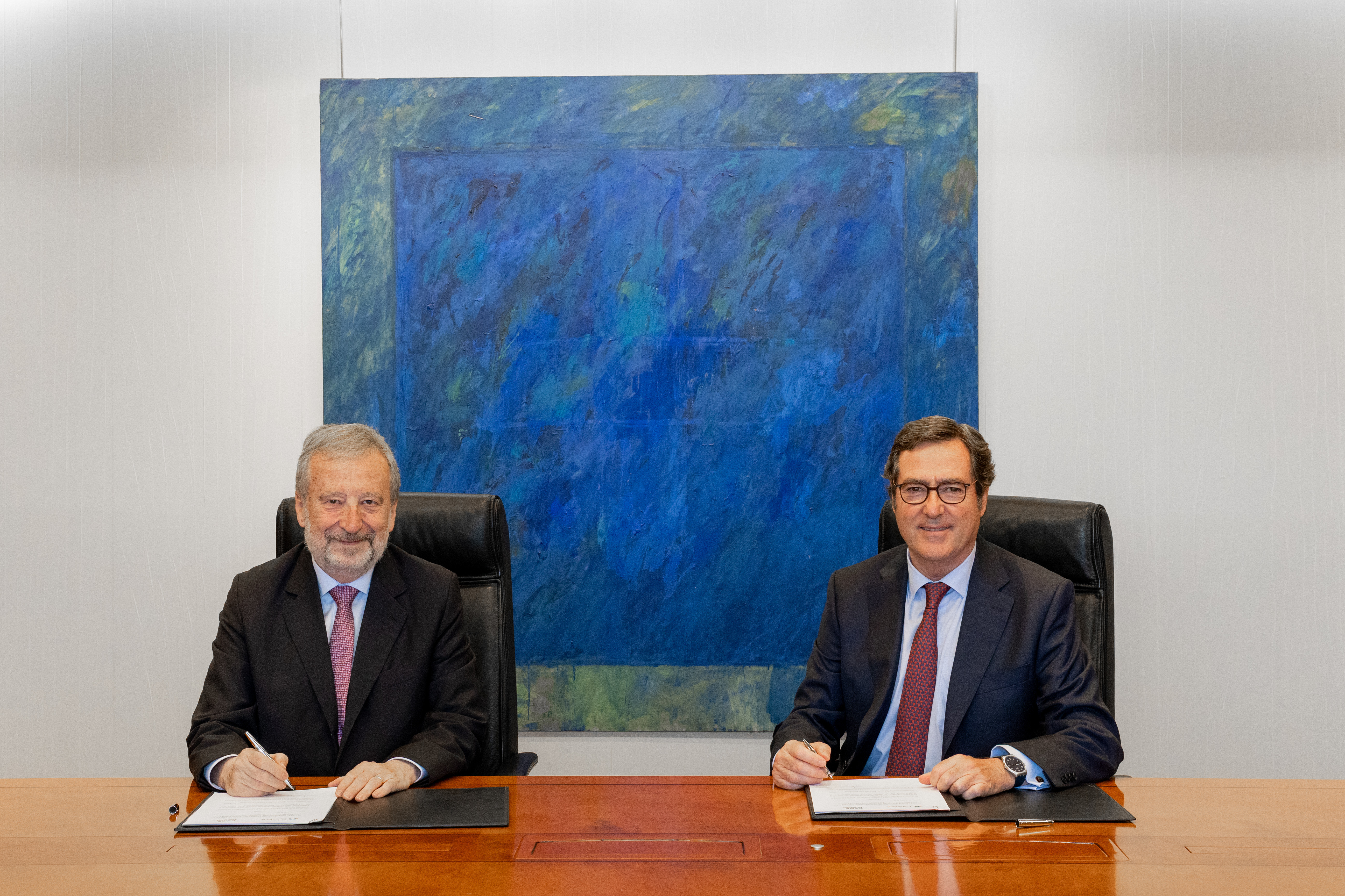 El presidente de CaixaBank, Tomás Muniesa, y el presidente de CEOE, Antonio Garamendi, en un momento de la firma.