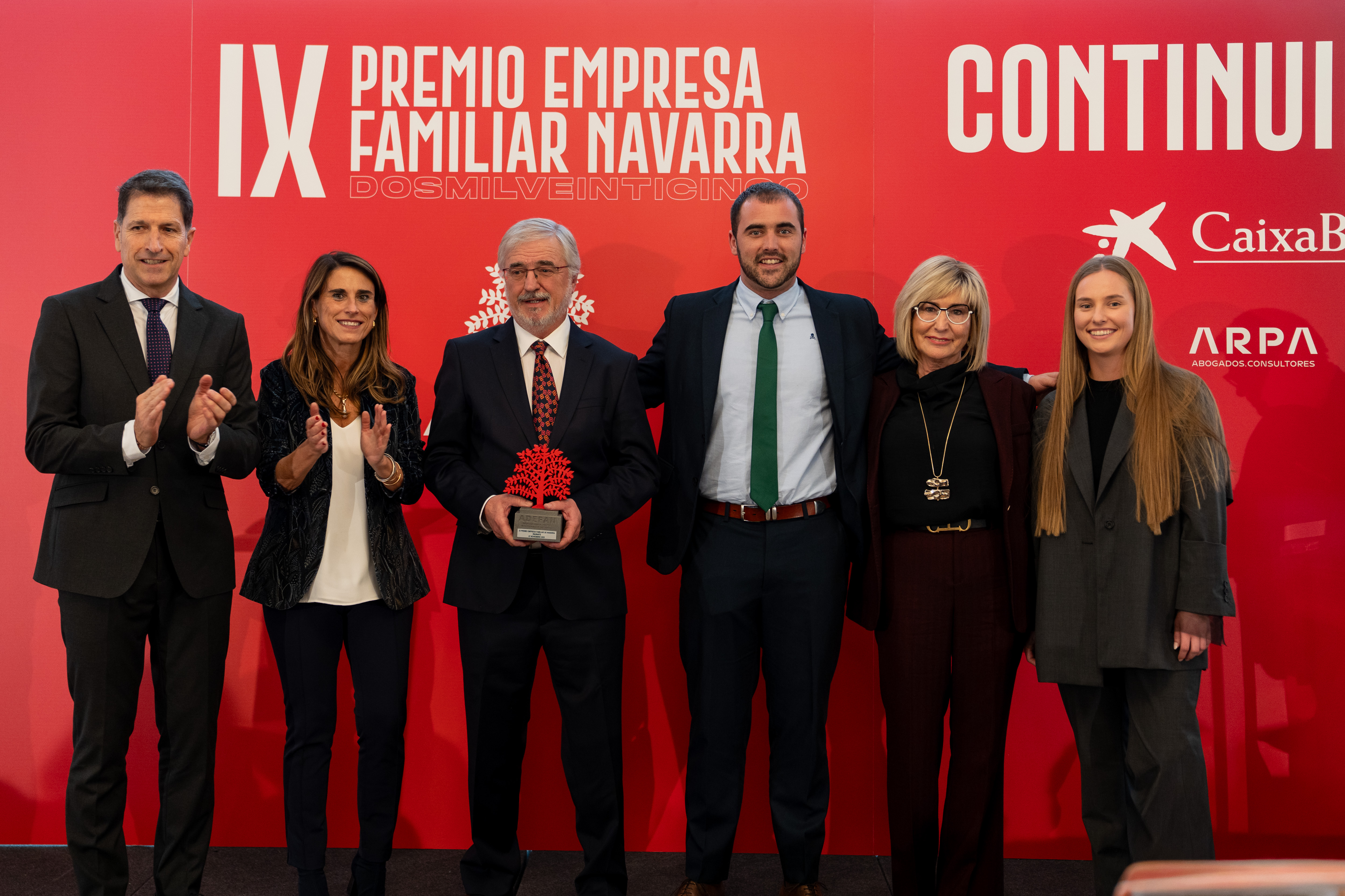 Isabel Moreno, directora territorial Ebro de CaixaBank, junto con la familia y empresa galardonada, e Iñaki Ecay, presidente de ADEFAN.
