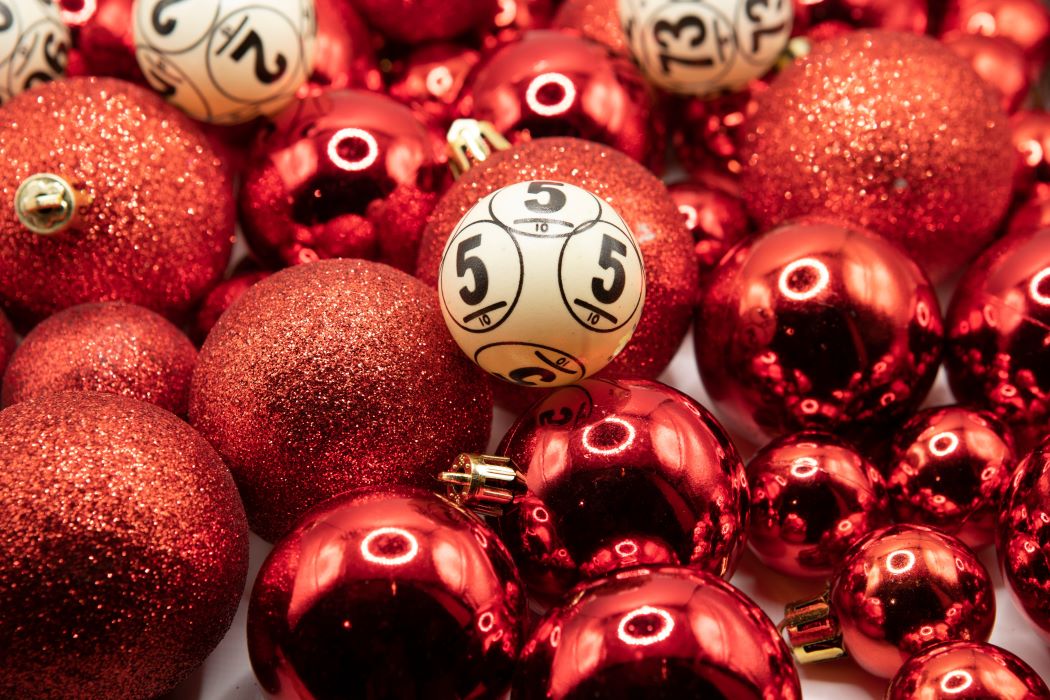Bola de lotería con un número impreso rodeada de adornos de Navidad