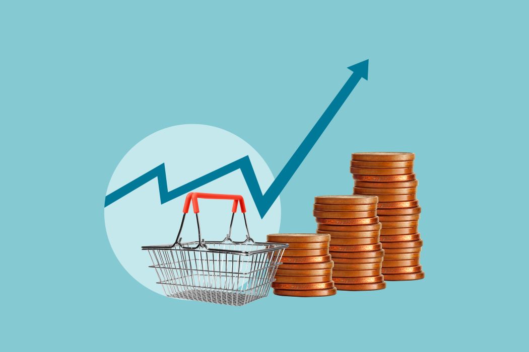 Cesta de compra junto a pilas de monedas y una flecha ascendente que indica aumento de precios