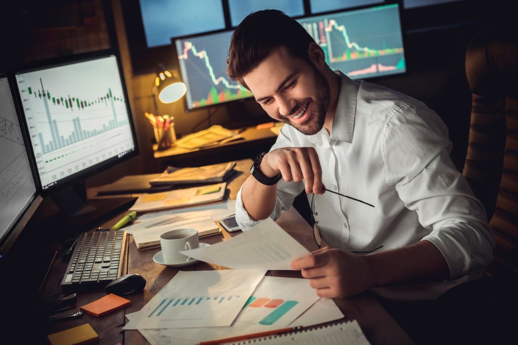 Trader trabaja frente a varias pantallas de ordenador
