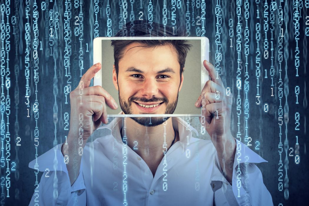 Persona sosteniendo una tableta frente al rostro, rodeada de un fondo digital con números y código en tonos azulados