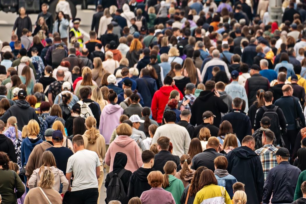 Multitud de personas caminando en la misma dirección por una calle concurrida