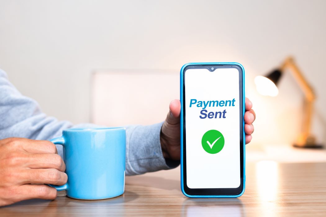 Persona sostenint un telèfon mòbil que mostra a la pantalla el missatge 