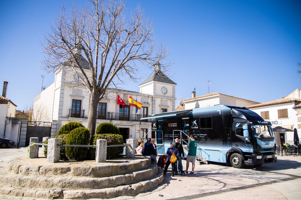 Oficina mòbil de CaixaBank a la plaça del poble de Colmenar del Arroyo, Madrid, en un dia assolellat