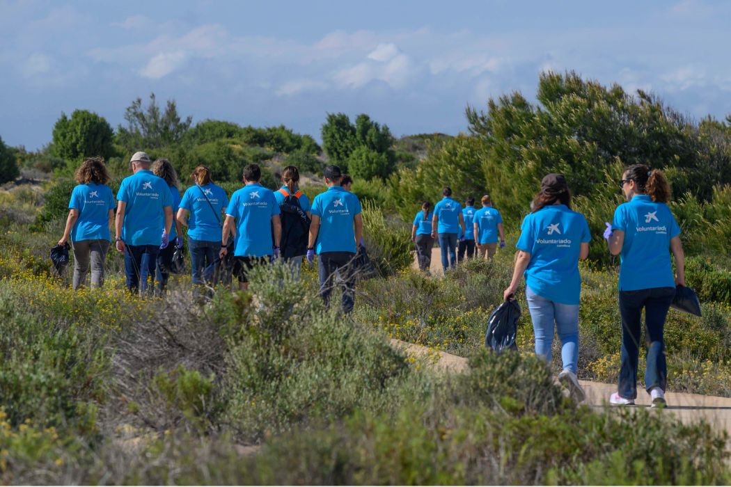 Grup de voluntaris de CaixaBank en una foto de grup al camp