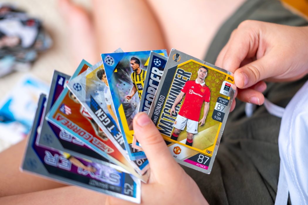 Unes mans subjecten un grapat de cromos de futbolistes