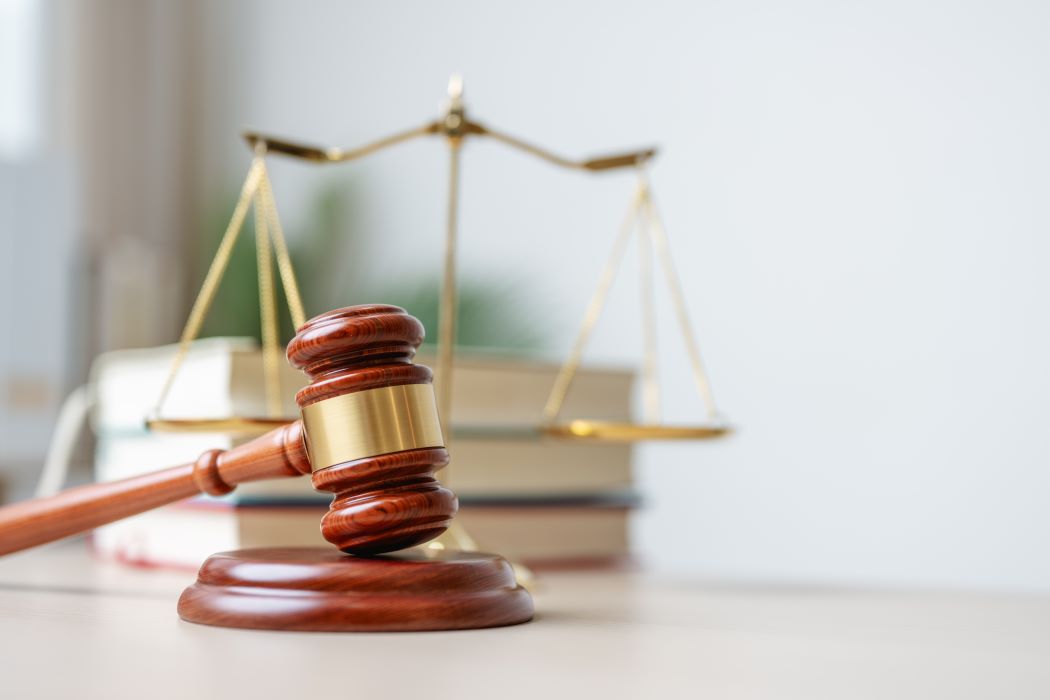 Mallet de jutge i balança de la justícia sobre una taula, símbols del marc legal en processos d’herència i successió.
