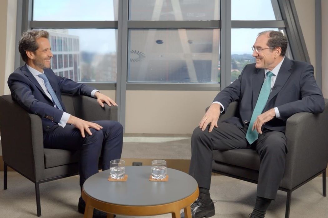 David Manso y Santiago Rubio conversan sentados en unes butacas en un espacio de despacho con vistas a la ciudad