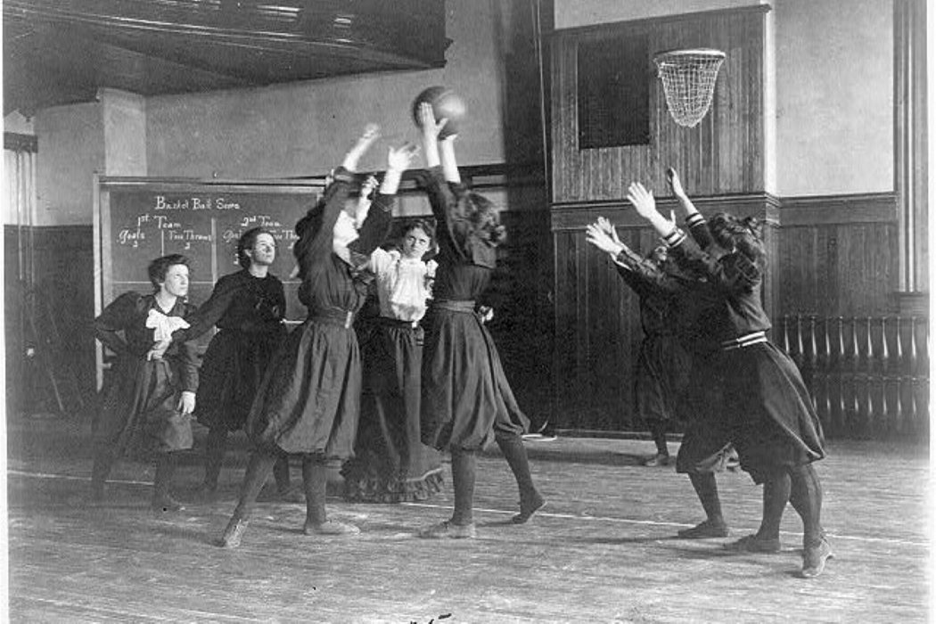 Varias chicas juegan al baloncesto con vestidos largos en una imagen antigua en blanco y negro