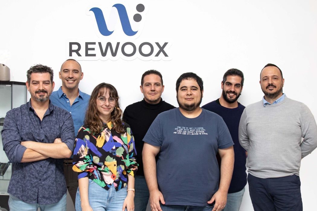 Siete personas posan en una sala delante del logo de Rewoox