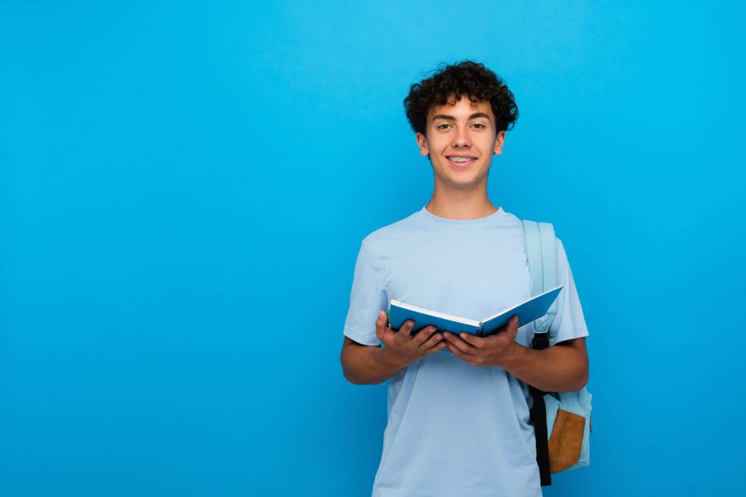 Jove estudiant amb un llibre obert a les mans