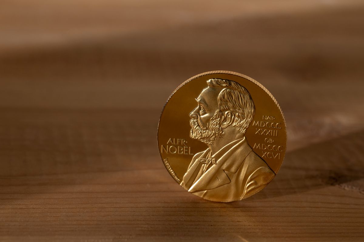 Medalla del Premi Nobel reposant sobre una superfície de fusta amb el retrat d'Alfred Nobel