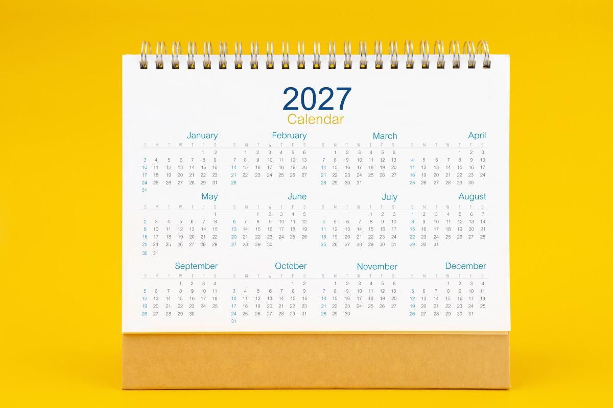 Calendario de sobremesa de 2027 con los doce meses del año, sobre fondo amarillo.