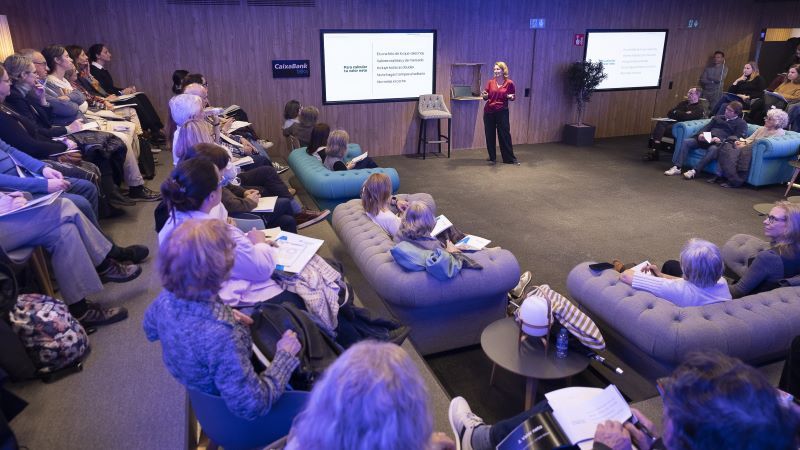 Natalia de Santiago da una charla ante un auditorio repleto de personas sentadas en sillas y sof&aacute;s
