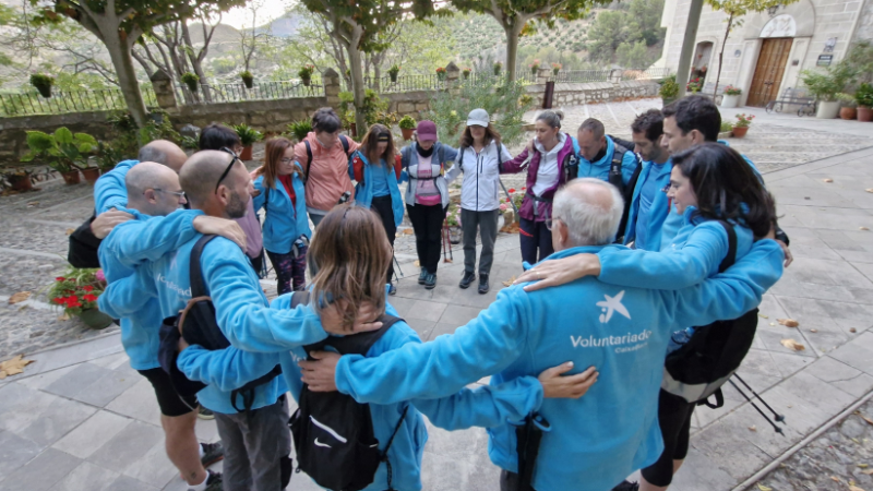Voluntarios de CaixaBank reunidos en corro prepar&aacute;ndose para el ascenso a Pico M&aacute;gina