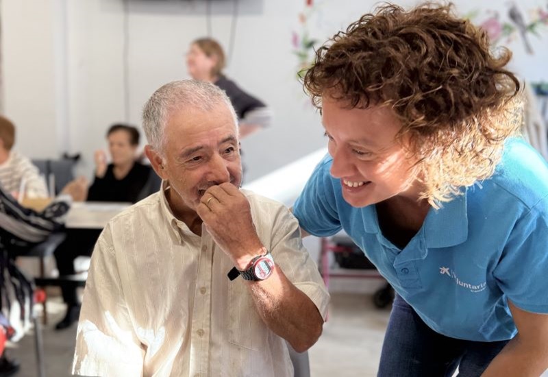 Una voluntaria de CaixaBank acompa&ntilde;a a uno de los ancianos participantes en el taller