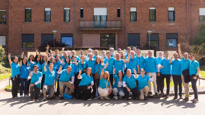 Grupo de voluntarios de CaixaBank en una foto de grupo en la puerta de un edificio de ladrillo