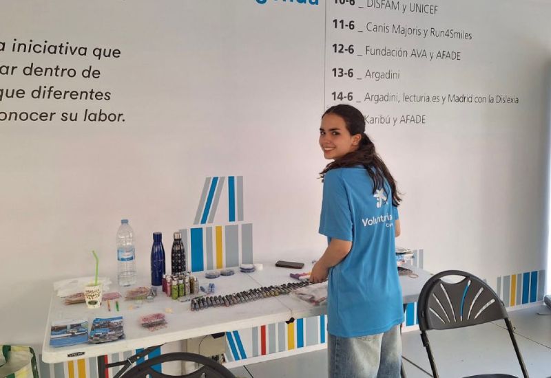 Una joven voluntaria de CaixaBank ante una mesa en una de las actividades organizadas