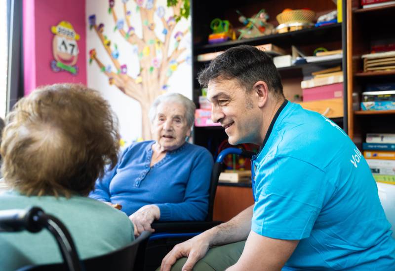Una voluntaria de CaixaBank charla con una persona mayor en una de las actividades s&eacute;nior de voluntariado