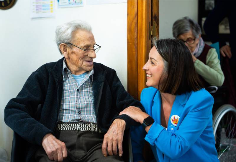 Una voluntaria de CaixaBank charla con una persona mayor en una de las actividades s&eacute;nior de voluntariado
