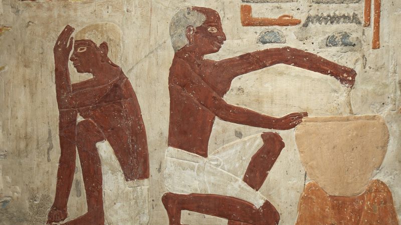 En el Antiguo Egipto el pan se utilizaba como salario y garantizaba la estabilidad social Pintura mural del Antiguo Egipto con figuras de perfil realizando tareas, una manipulando un recipiente, sobre fondo claro con jeroglíficos y desgaste visible