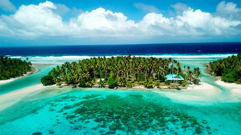 Vista a&eacute;rea de Islas Marshall rodeada de aguas cristalinas turquesas y vegetaci&oacute;n de palmeras